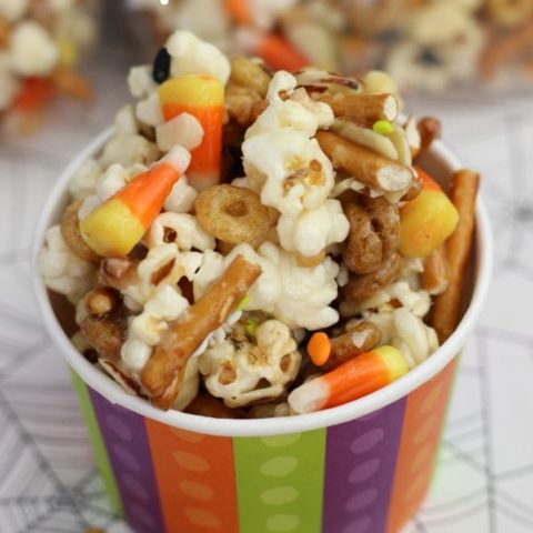 Gooey Halloween Popcorn Crunch - Popcorn, pretzels, candy corn, almonds, and cereal all mixed up in the most wonderfully addicting sugar coating!