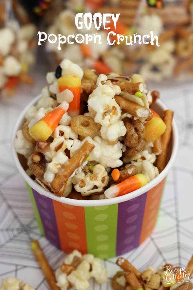 Gooey Halloween Popcorn Crunch - Popcorn, pretzels, candy corn, almonds, and cereal all mixed up in the most wonderfully addicting sugar coating!