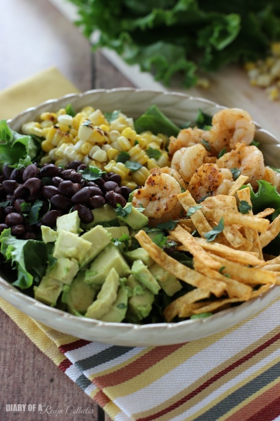 Southwest Shrimp Salad - Grilled shrimp and corn, black beans, diced avocado, and crispy southwest tortilla strips piled onto a bed of green leaf lettuce and topped with a mexi-ranch dressing.