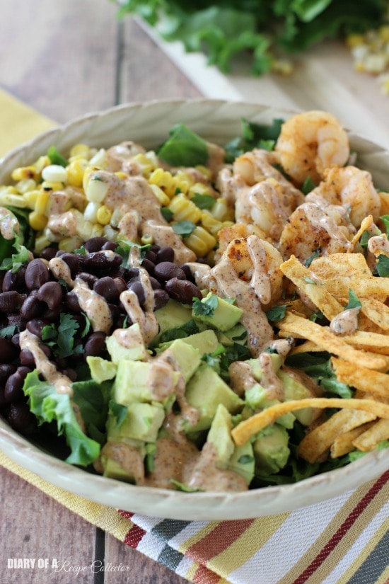 Southwest Shrimp Salad - Grilled shrimp and corn, black beans, diced avocado, and crispy southwest tortilla strips piled onto a bed of green leaf lettuce and topped with a mexi-ranch dressing.