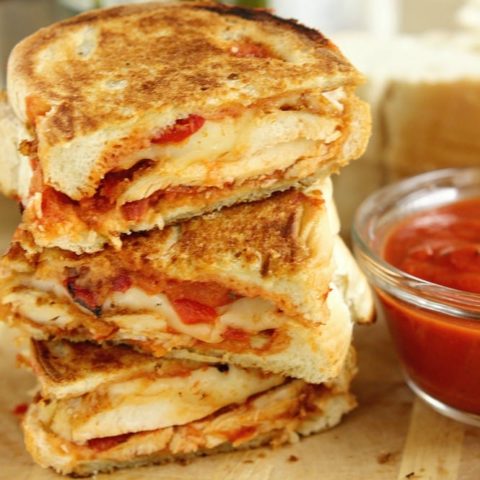 Chicken Parmesan Panini - Grilled sandwiches filled with crispy, breaded chicken breasts topped with marinara sauce, provolone, and roasted red bell peppers.