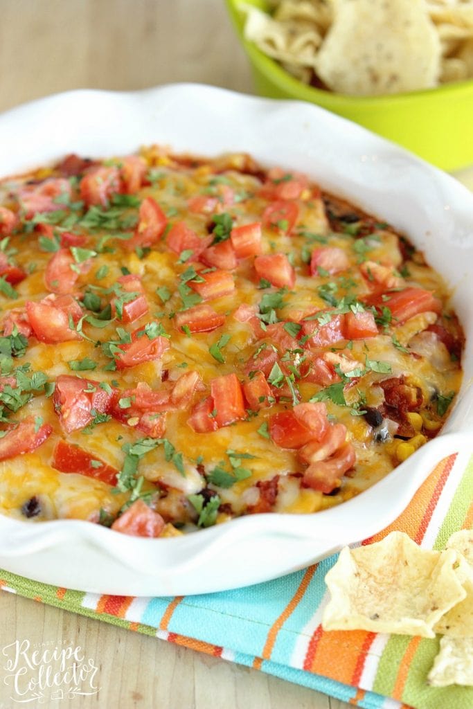 Southwestern Bean & Cheese Dip - A quick oven-baked dip made with layers of cream cheese, salsa, black beans, corn, melted cheese, tomatoes, and cilantro!