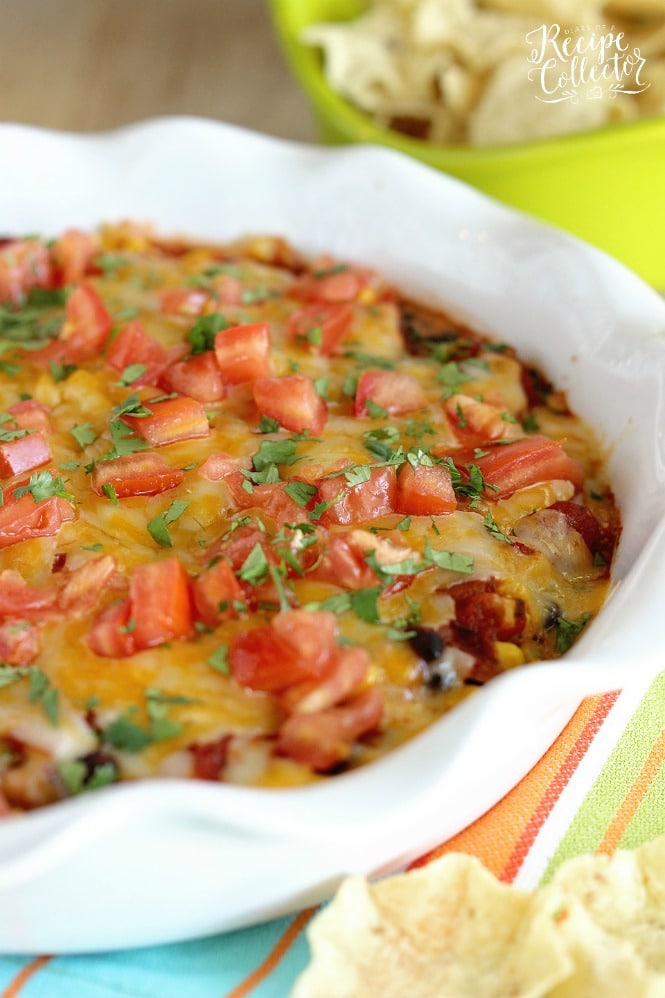 Southwestern Bean & Cheese Dip - A quick oven-baked dip made with layers of cream cheese, salsa, black beans, corn, melted cheese, tomatoes, and cilantro!