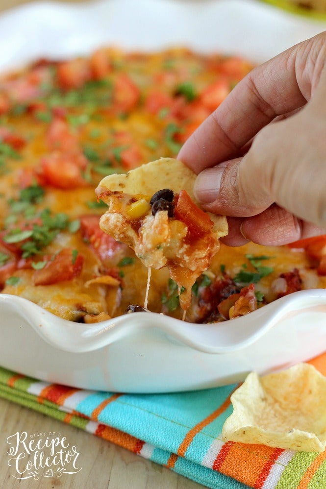 Southwestern Bean & Cheese Dip - A quick oven-baked dip made with layers of cream cheese, salsa, black beans, corn, melted cheese, tomatoes, and cilantro!