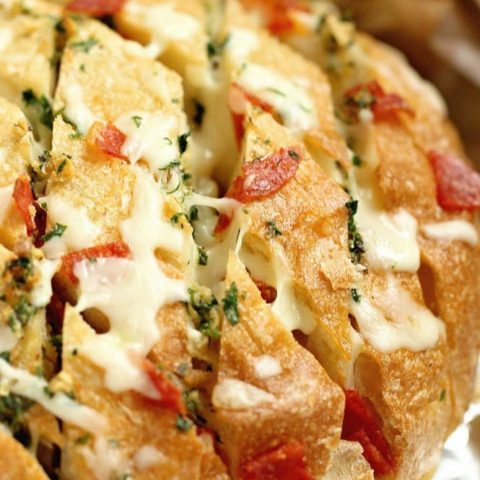 Cheesy Pepperoni Garlic Pull Apart Bread is a packed with tons of garlic herb flavor and makes the perfect appetizer and snack idea!