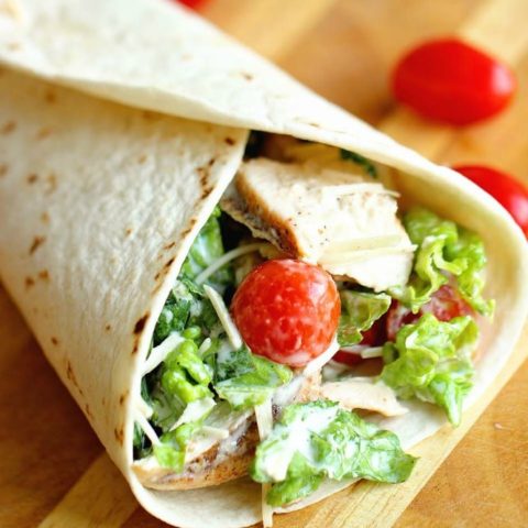 Chicken Caesar Wrap - A quick and easy lunch or dinner recipe filled with grilled chicken, chopped romaine, grape tomatoes, Parmesan cheese, and caesar dressing.  They are great to make ahead for your week too!