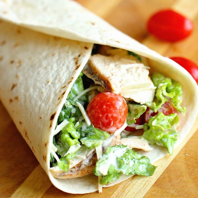 Chicken Caesar Wrap - A quick and easy lunch or dinner recipe filled with grilled chicken, chopped romaine, grape tomatoes, Parmesan cheese, and caesar dressing.  They are great to make ahead for your week too!