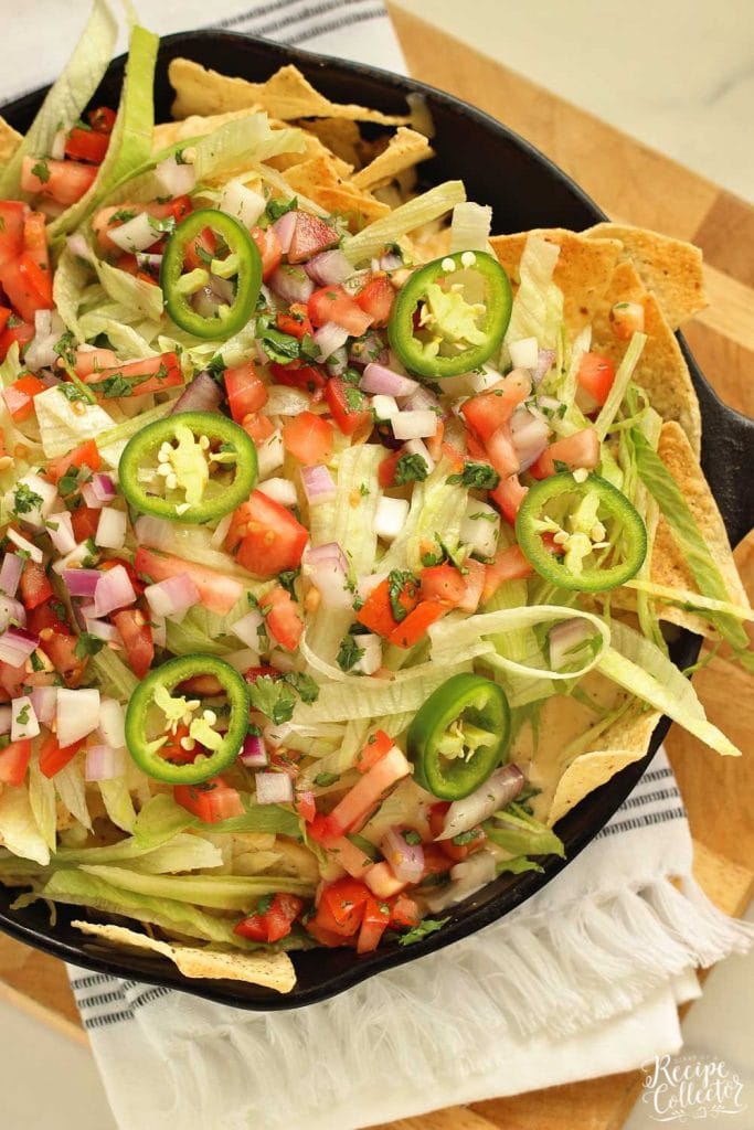 Loaded Skillet Nachos - Layers of tortilla chips, black beans, white cheese sauce, shredded Pepperjack, lettuce, and pico make this the ultimate snack or dinner idea!