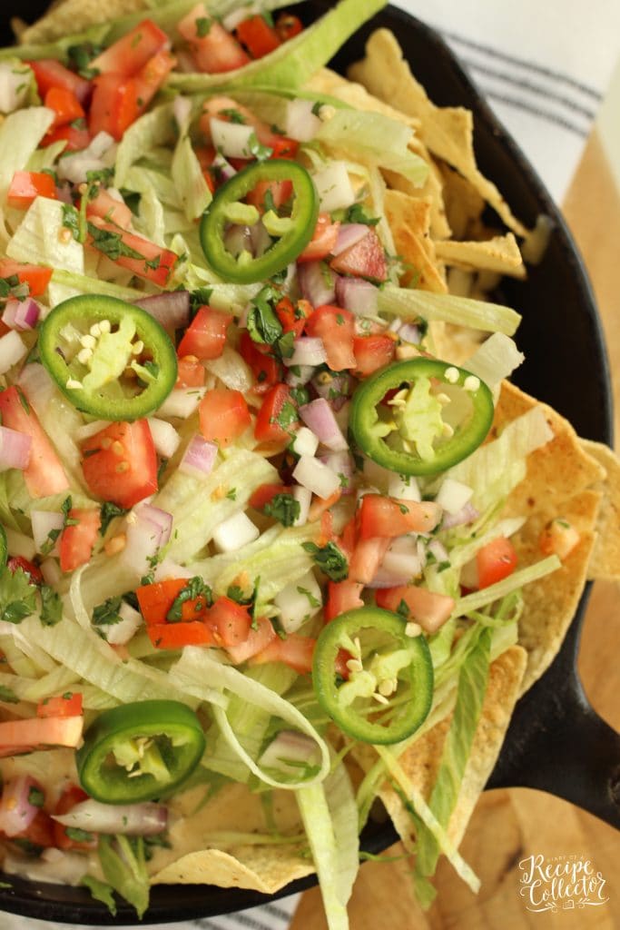 Loaded Skillet Nachos - Layers of tortilla chips, black beans, white cheese sauce, shredded Pepperjack, lettuce, and pico make this the ultimate snack or dinner idea!