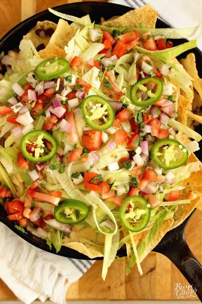 Loaded Skillet Nachos - Layers of tortilla chips, black beans, white cheese sauce, shredded Pepperjack, lettuce, and pico make this the ultimate snack or dinner idea!