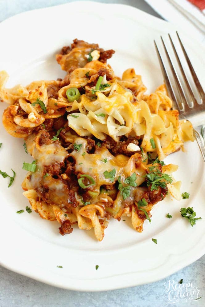 Mexican Noodle Bake - An easy layered casserole filled with seasoned ground beef, a Mexican flavored sauce, cheesy noodles, and topped with shredded cheese.  You will not be slaving away on this delicious meal, I promise!