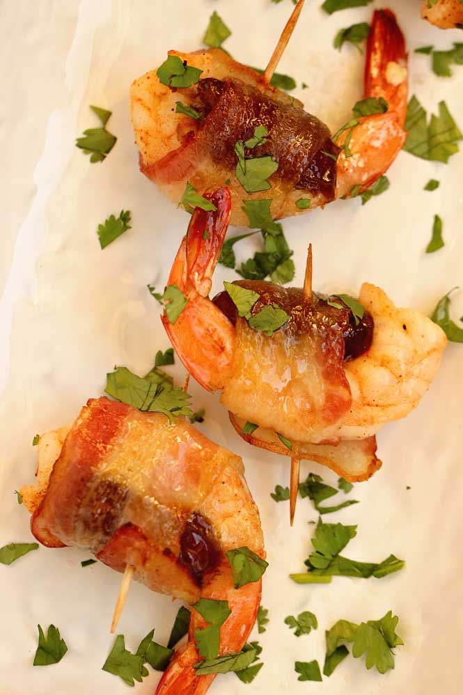 Date-Stuffed Shrimp with Praline Sauce- Creole seasoned shrimp stuffed with mascarpone filled date, wrapped in bacon, topped with pecan praline sauce and baked.  This makes a great appetizer for the holidays! 