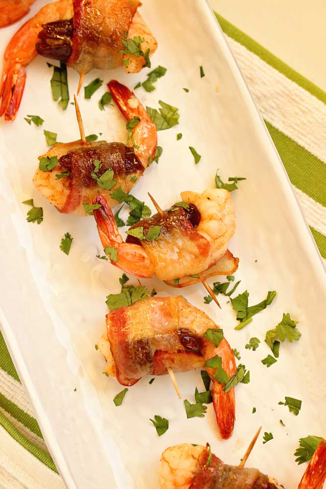 Date-Stuffed Shrimp with Praline Sauce- Creole seasoned shrimp stuffed with mascarpone filled date, wrapped in bacon, topped with pecan praline sauce and baked.  This makes a great appetizer for the holidays! 