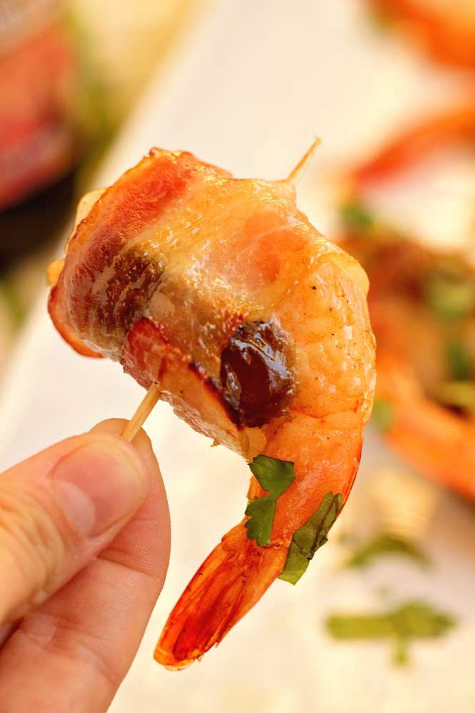 Date-Stuffed Shrimp with Praline Sauce- Creole seasoned shrimp stuffed with mascarpone filled date, wrapped in bacon, topped with pecan praline sauce and baked.  This makes a great appetizer for the holidays! 