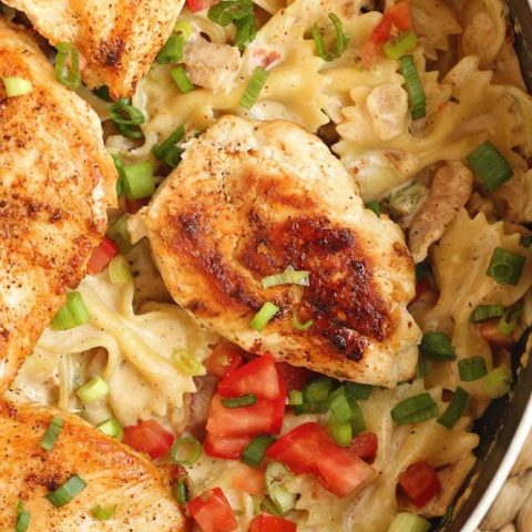 Roasted Garlic Cajun Chicken Pasta - Creole seasoned chicken breasts over bow tie pasta tossed with a delicious roasted garlic cream sauce. 