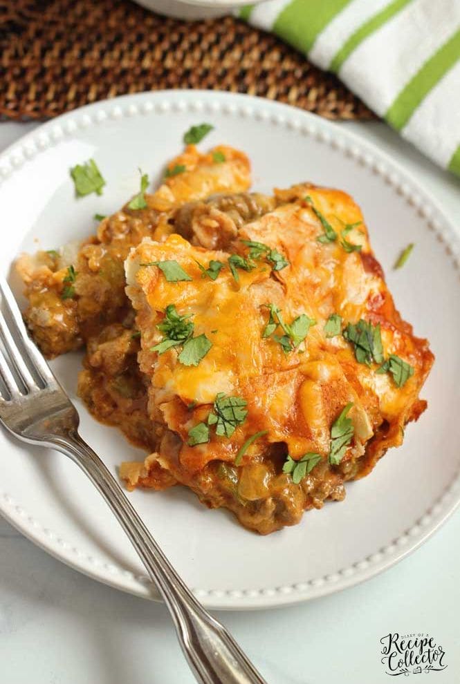 Baked Enchilada Casserole - A total crowd pleasing Mexican casserole recipe filled with layers of white corn tortillas, enchilada sauce, refried beans, meat sauce, and shredded cheese.  Plus, it has a little secret ingredient to give it that great flavor! 