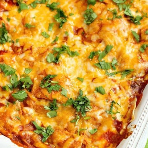 Baked Enchilada Casserole - A total crowd pleasing Mexican casserole recipe filled with layers of white corn tortillas, enchilada sauce, refried beans, meat sauce, and shredded cheese.  Plus, it has a little secret ingredient to give it that great flavor! 