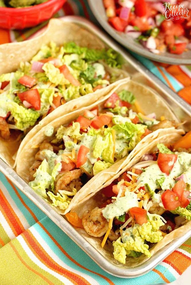 Ultimate Shrimp Tacos - Seasoned shrimp sauteed with peppers, and onions wrapped in a tortilla and topped with pico de gallo, cilantro dip, cheese, and napa cabbage.