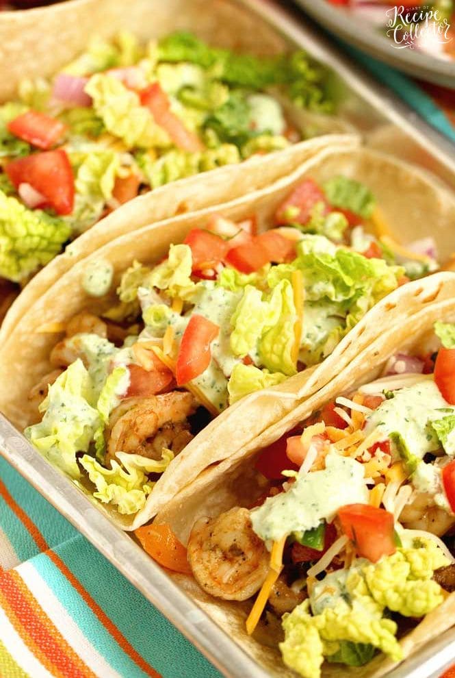 Ultimate Shrimp Tacos - Seasoned shrimp sauteed with peppers, and onions wrapped in a tortilla and topped with pico de gallo, cilantro dip, cheese, and napa cabbage.