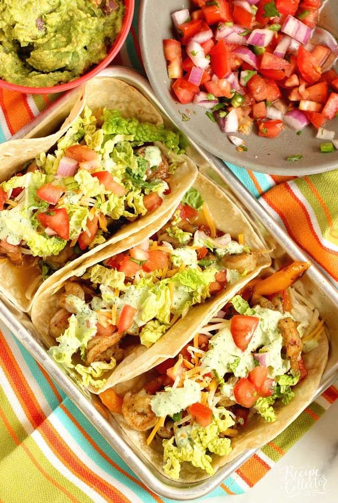 Ultimate Shrimp Tacos - Seasoned shrimp sauteed with peppers, and onions wrapped in a tortilla and topped with pico de gallo, cilantro dip, cheese, and napa cabbage.