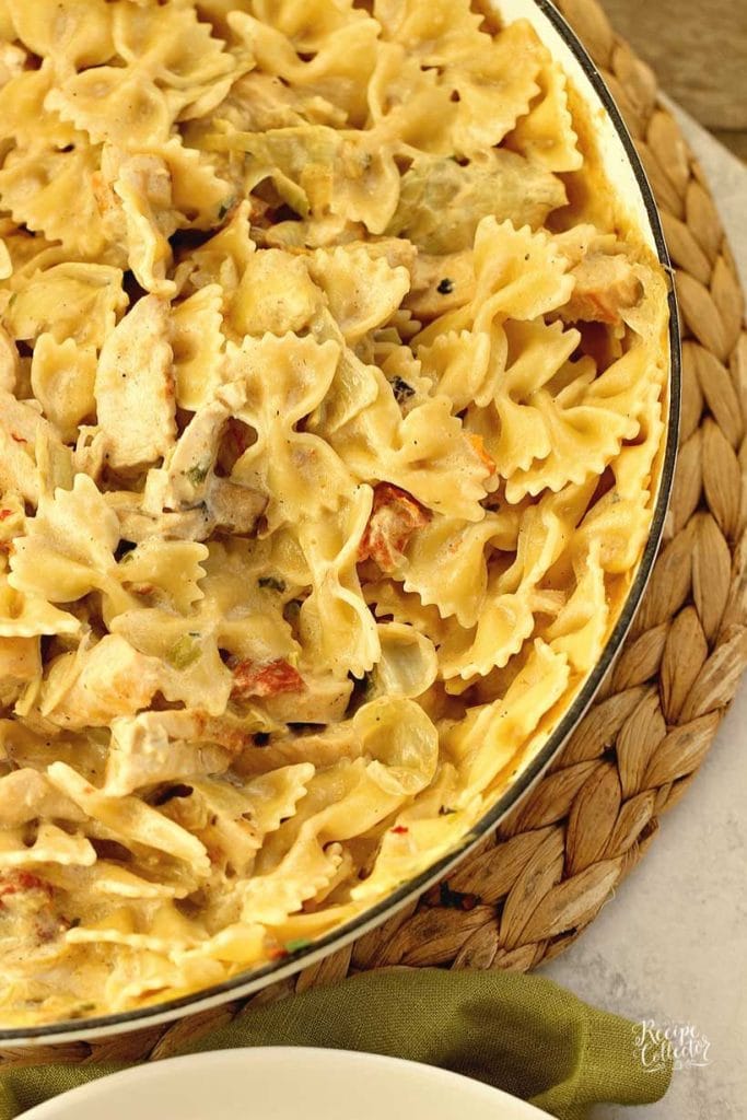 Copycat Spicy Romano Chicken Pasta - Make this creamy restaurant-style chicken pasta made with bow-tie noodles, sun-dried tomatoes, artichoke hearts, mushrooms, and grilled chicken tossed in a creamy dreamy sauce.